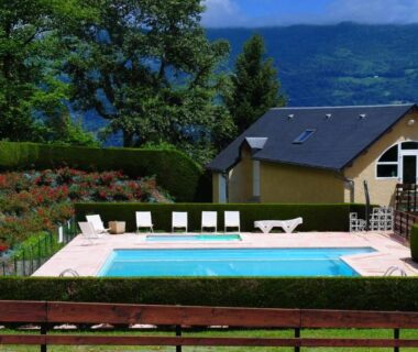 Piscine extérieure entourée de chaises au Camping l'Ideal