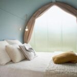 Chambre cosy avec lit et hublot arrondi au Camping la Chaumière