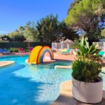 Piscine extérieure avec toboggan et transats au Camping la Croix du Sud
