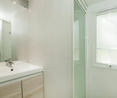 Salle de bain avec lavabo et miroir au Camping la Croix du Sud