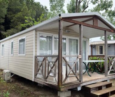 Mobil-home avec terrasse en bois sur sol herbeux au Camping la Marine