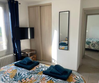 Chambre avec lit serviettes pliées et télévision au Camping la Paoute