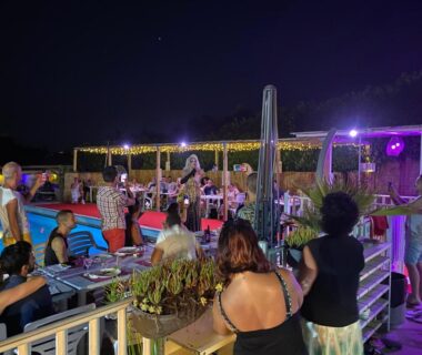 Terrasse au bord de la piscine avec concert en soirée au Camping la Paoute