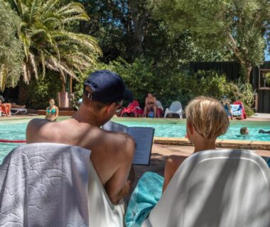 Bord de piscine avec transats et baigneurs au Camping la Peiriere Chalet et Mobile-home