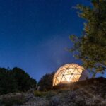 Dôme illuminé sous ciel étoilé au Camping la Peiriere Évasion en Dôme