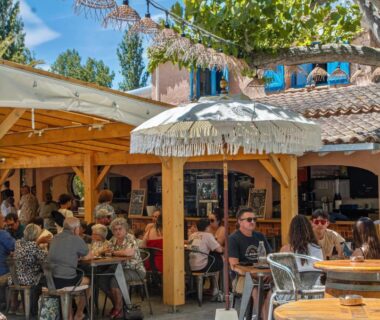 Terrasse ombragée avec convives et bar au Camping la Peiriere Évasion en Dôme