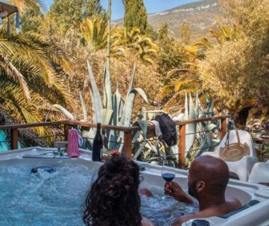 Bain à remous extérieur entouré de palmiers au Camping la Peiriere – Évasion en Dôme