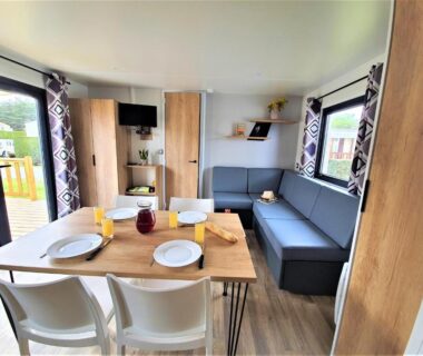 Séjour avec table dressée et banquette dans le mobil-home du Camping la Plage