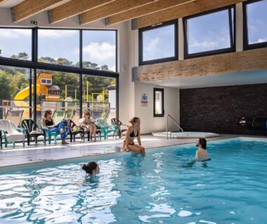 Piscine intérieure avec baies vitrées et toboggans au Camping la Prairie