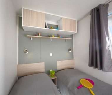 Chambre avec deux lits et fenêtre dans le Camping la Simioune en Provence