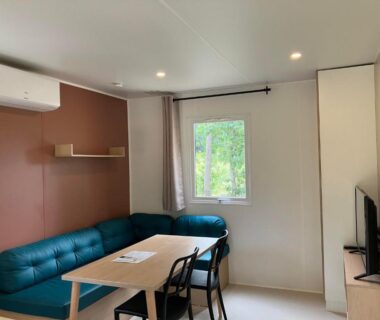 Intérieur mobil-home avec canapé et table au Camping la Simioune
