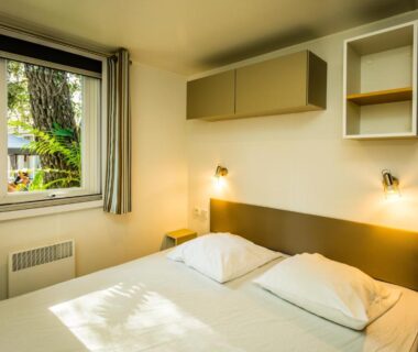 Chambre double avec fenêtre sur jardin dans le mobil home du Camping la Sousta