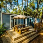 Terrasse en bois avec table et parasol au Camping la Sousta