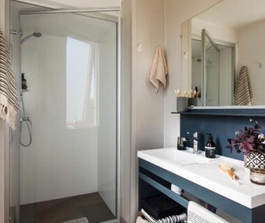 Salle de bains avec douche vitrée et vasque au Camping la Sousta