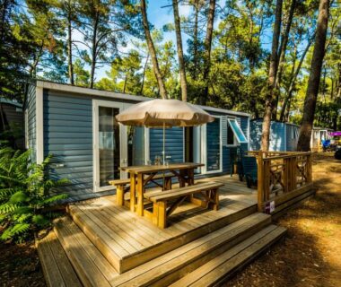 Terrasse en bois avec table et parasol au Camping la Sousta