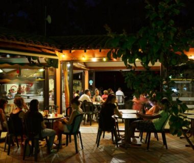 Terrasse extérieure éclairée avec convives au Camping la Sousta****