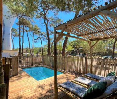 Terrasse en bois avec piscine et chaises longues au Camping la Tamarissière