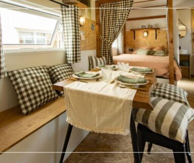 Intérieur mobil-home avec coin repas et lit au Camping la Tamarissière