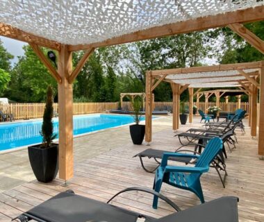 Bord de piscine avec transats et pergolas au Camping la Venise Verte