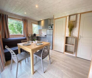 Intérieur du mobil-home avec coin repas et kitchenette au Camping la Venise Verte