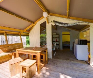 Terrasse couverte avec table en bois et kitchenette au Camping la Venise Verte