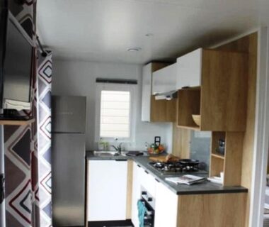 Intérieur cuisine et coin salon dans le mobil-home du Camping le Balcon de la Baie
