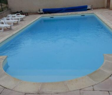 Piscine extérieure avec chaises longues au camping Le Bois Jahan