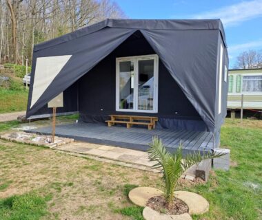 Terrasse avec tente lodge et petit palmier au Camping le Bois Jahan