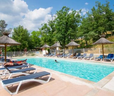 Piscine extérieure avec transats au Camping le Colorado