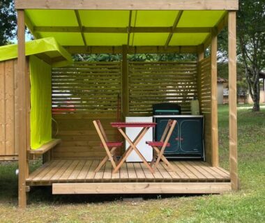 Terrasse couverte avec table et deux chaises du Camping le Convivial Cop'Camp 2 personnes
