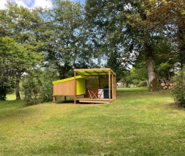 Clairière herbeuse et petit chalet en bois dans le Camping le Convivial Cop'Camp 2 personnes
