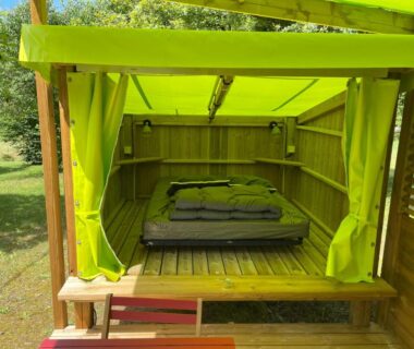 Cabane extérieure avec lit et rideaux dans le camping Le Convivial Cop'Camp 2 personnes