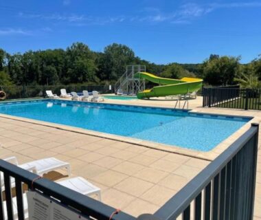 Piscine extérieure avec toboggan et transats au Camping le Convivial Mobil home 3 chambres
