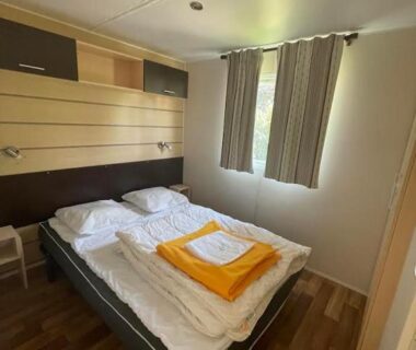 Chambre avec lit double et serviettes pliées dans le Camping le Convivial Mobil home 3 chambres