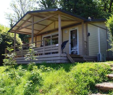 Sur une parcelle gazonnée mobil home avec terrasse et escaliers dans le camping le Grand Cerf