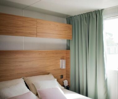 Chambre avec lit et coussins au Camping le Marache