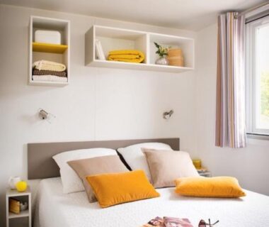 Chambre avec lit double et coussins jaunes dans le Camping le Mas des Sedaries