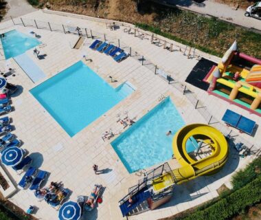 Piscine extérieure avec toboggan et transats au Camping le Mas des Sedaries