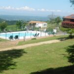 Piscine extérieure avec transats et mobil homes au Camping le Montbartoux