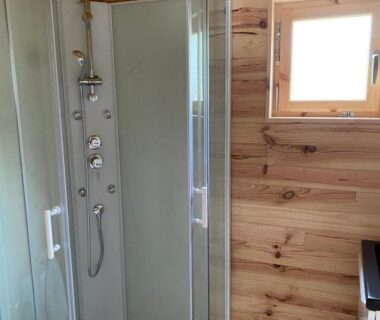 Salle de bain avec cabine de douche dans un chalet en bois au Camping le Montbartoux