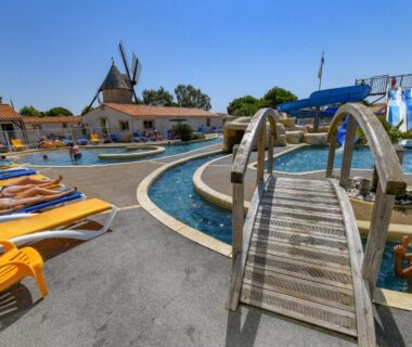Piscine avec toboggans et transats au Camping le Moulin de la Salle