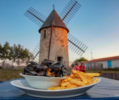Devant un moulin assiette de moules frites au Camping le Moulin de la Salle