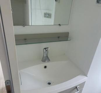 Salle de bain avec lavabo et miroir au Camping le Neptune 4 étoiles
