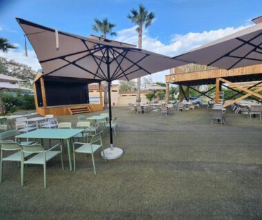 Terrasse extérieure avec parasols et tables au Camping le Neptune 4 étoiles
