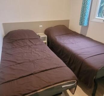 Chambre avec deux lits simples dans l'hébergement du Camping le Neptune 4 étoiles