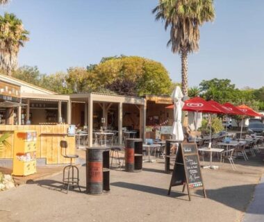 Terrasse extérieure avec bar et parasols au Camping le Neptune