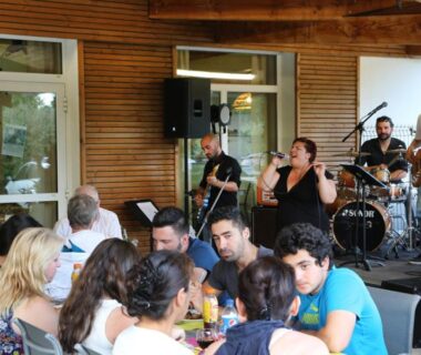 Terrasse couverte avec groupe musical et convives au Camping le Nid du Parc