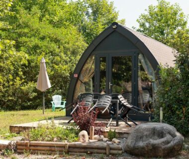 Terrasse et salon de jardin devant un pod de glamping au Camping le Pré Morjal