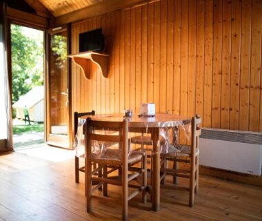 Coin repas intérieur dans un chalet en bois au Camping le Pré Morjal