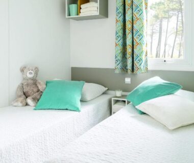 Chambre avec deux lits et fenêtre au Camping le Rancho